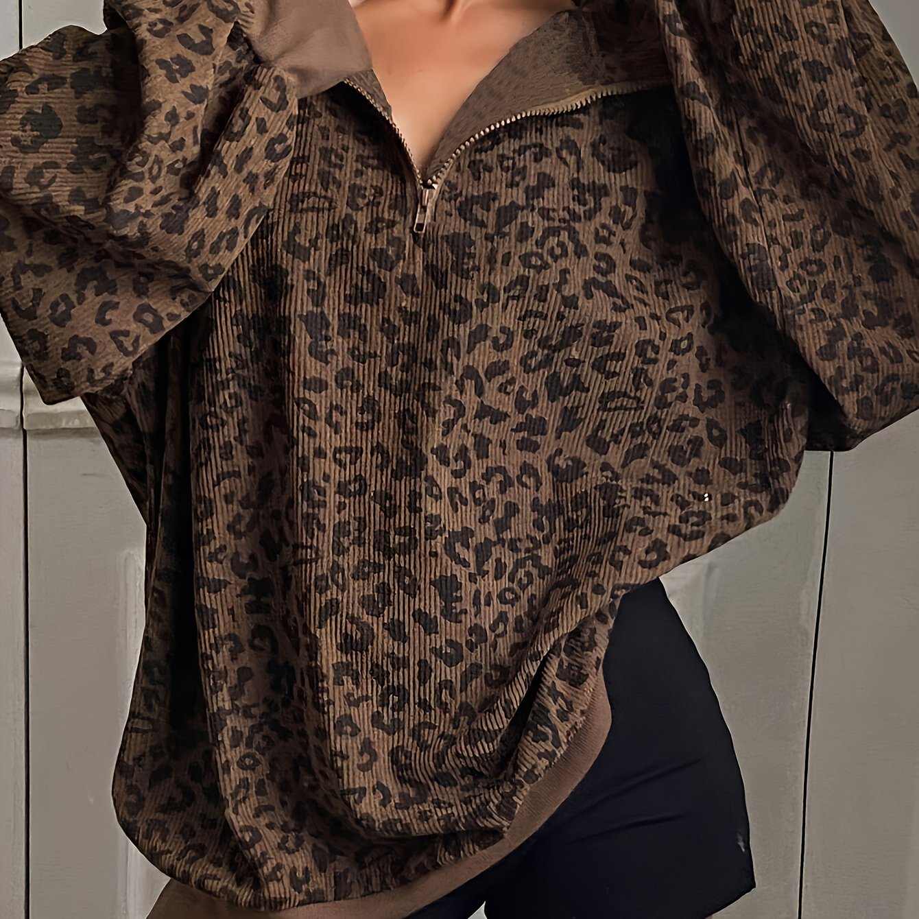 Side view of the oversized leopard quarter zip sweatshirt showing sleeve volume