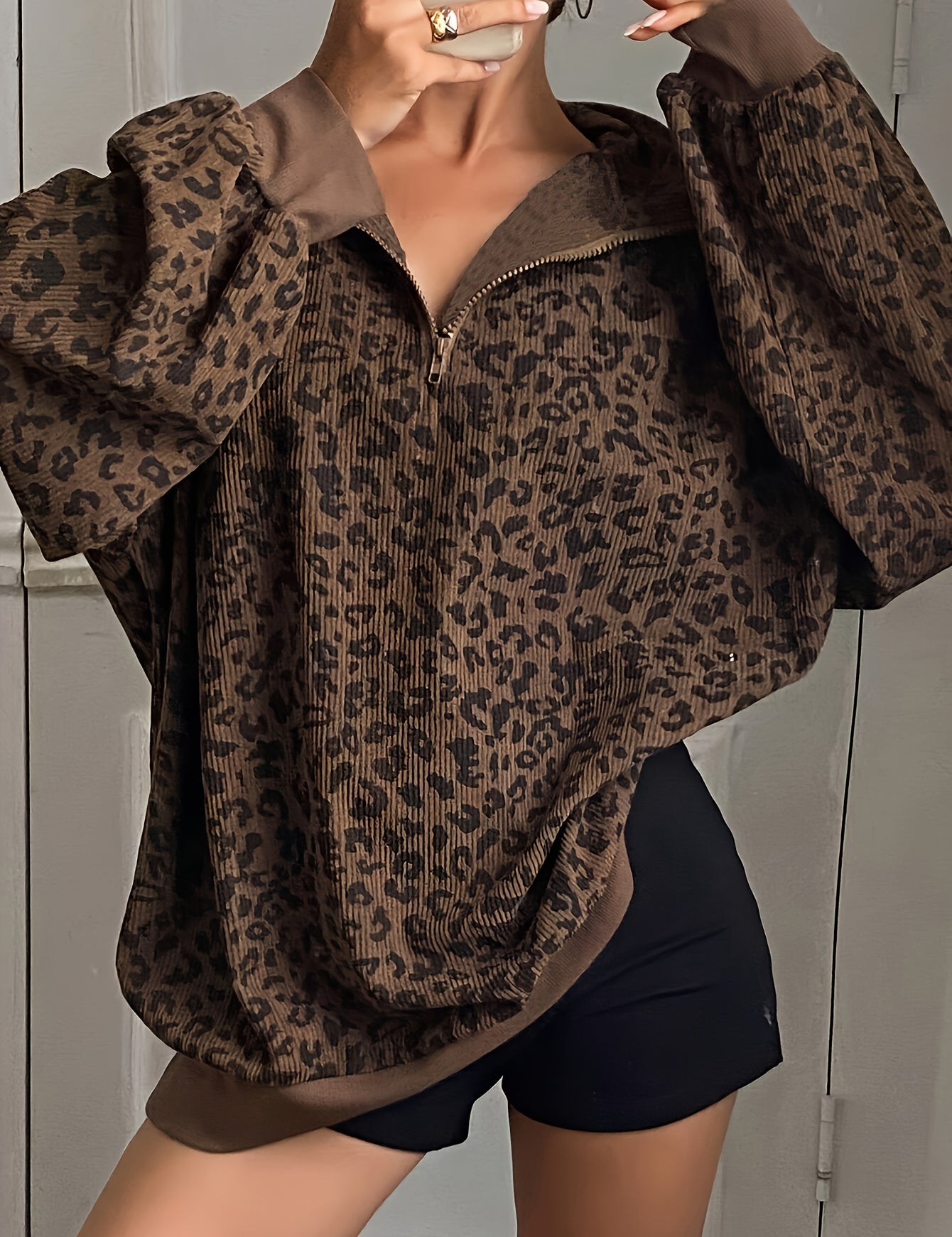 Oversized leopard print quarter zip sweatshirt in brown, worn open at the collar