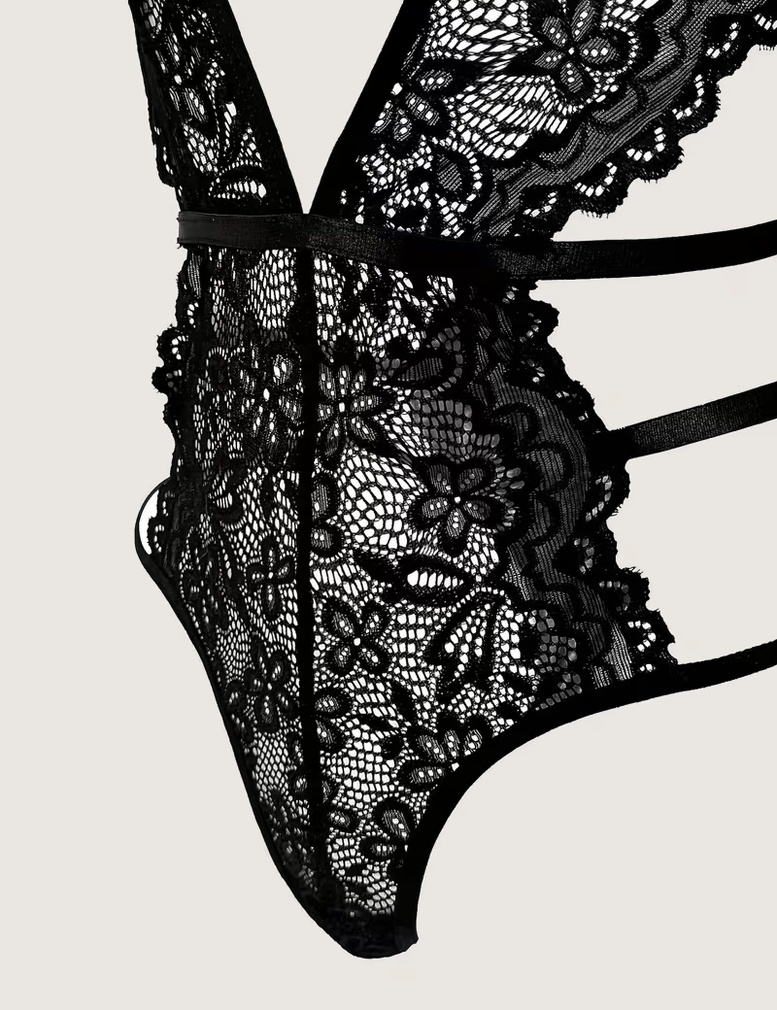 Close view of the triple hip straps and floral lace panel on the black bodysuit