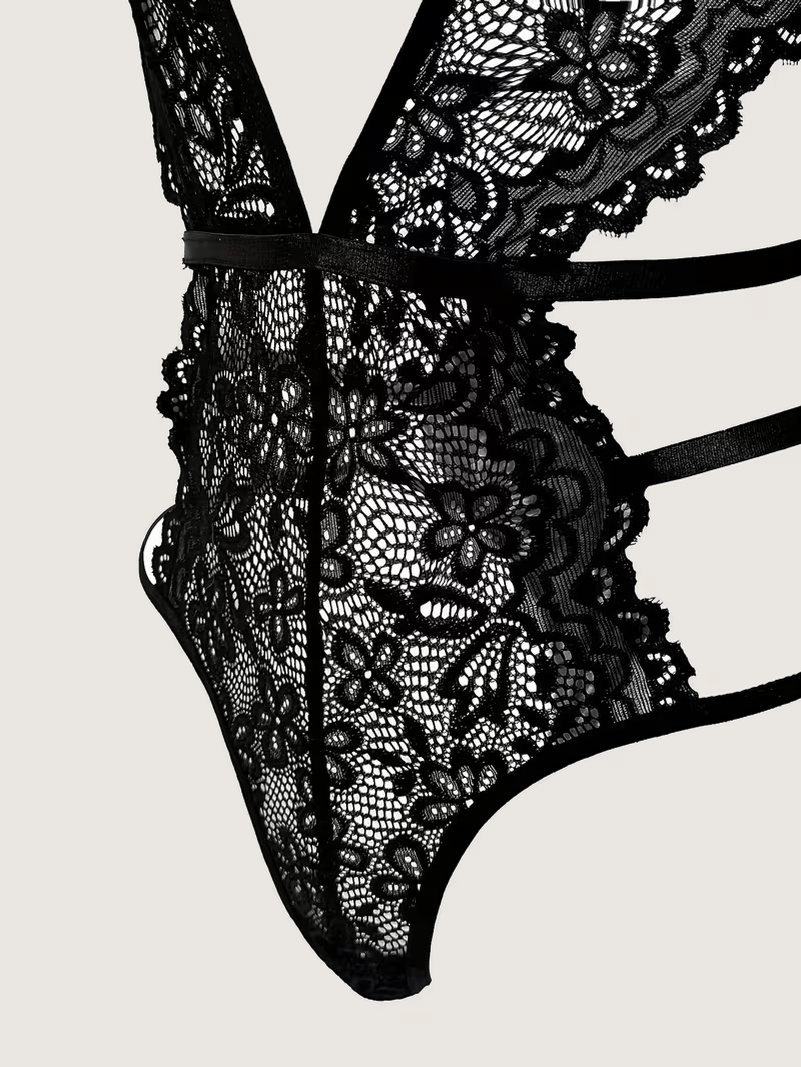 Close view of the triple hip straps and floral lace panel on the black bodysuit