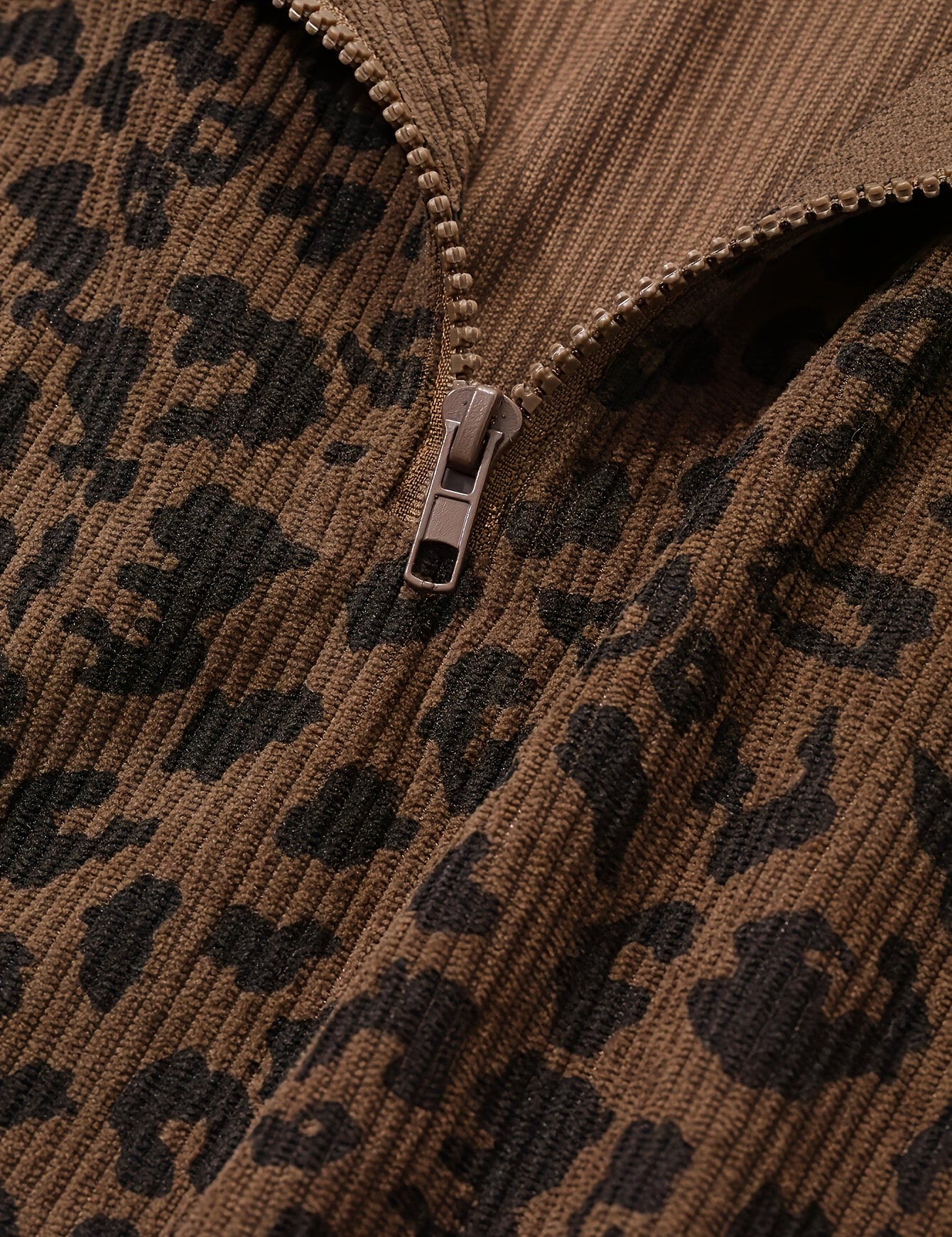Close detail of the quarter zip pull and the waffle-textured leopard knit