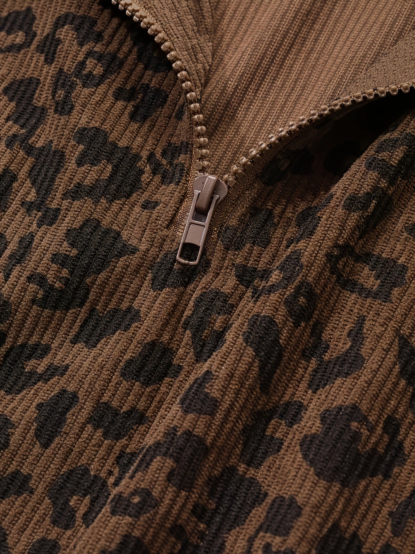 Close detail of the quarter zip pull and the waffle-textured leopard knit