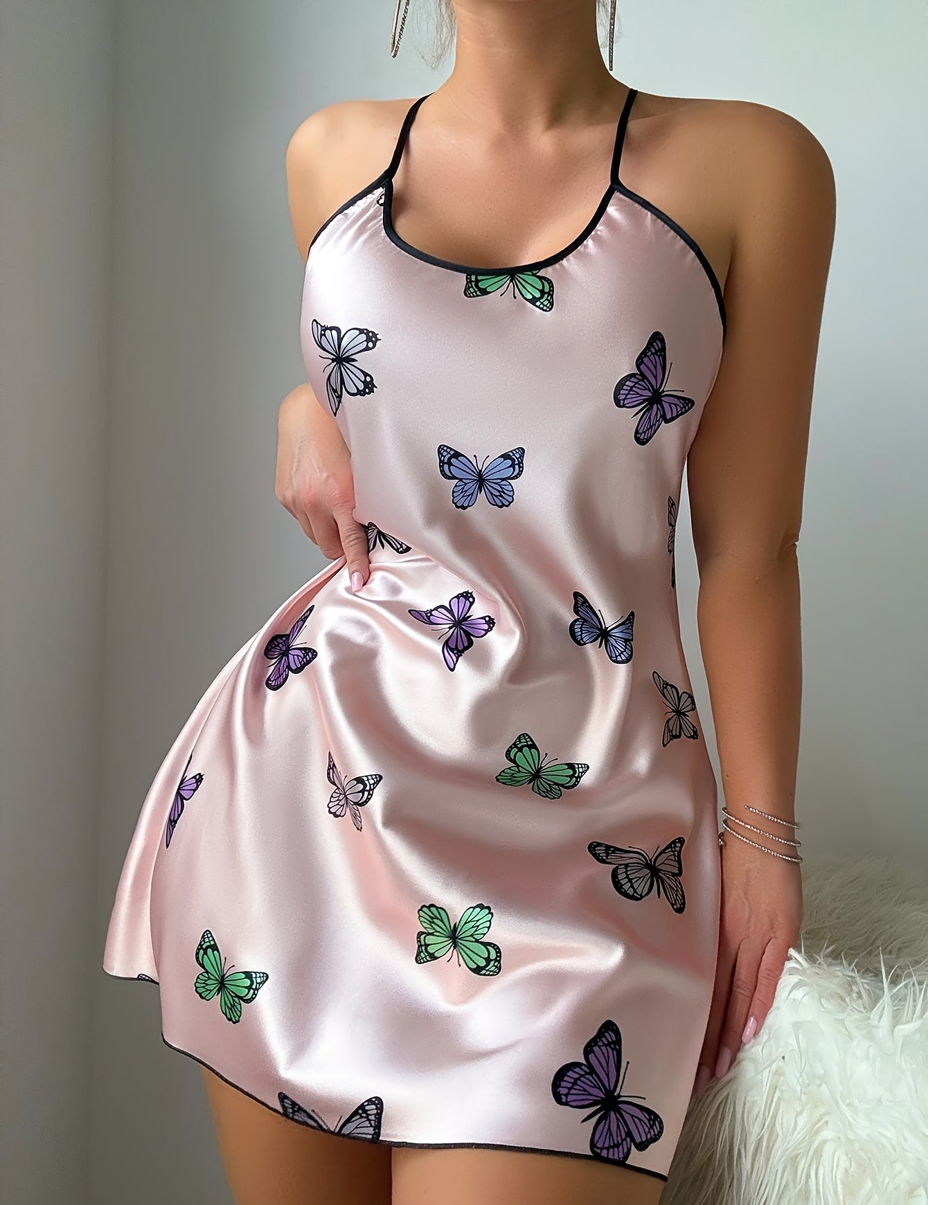 Butterfly print satin slip dress showing the flared cut and hem