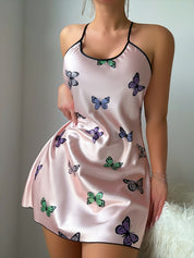 Butterfly print satin slip dress showing the flared cut and hem