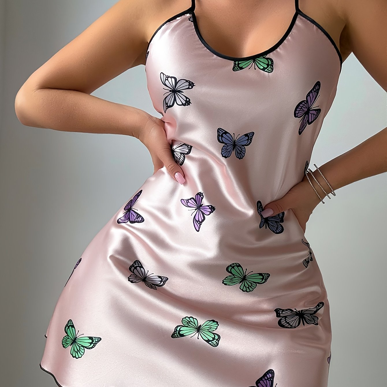 Close view of the butterfly print and satin finish on the pink chemise