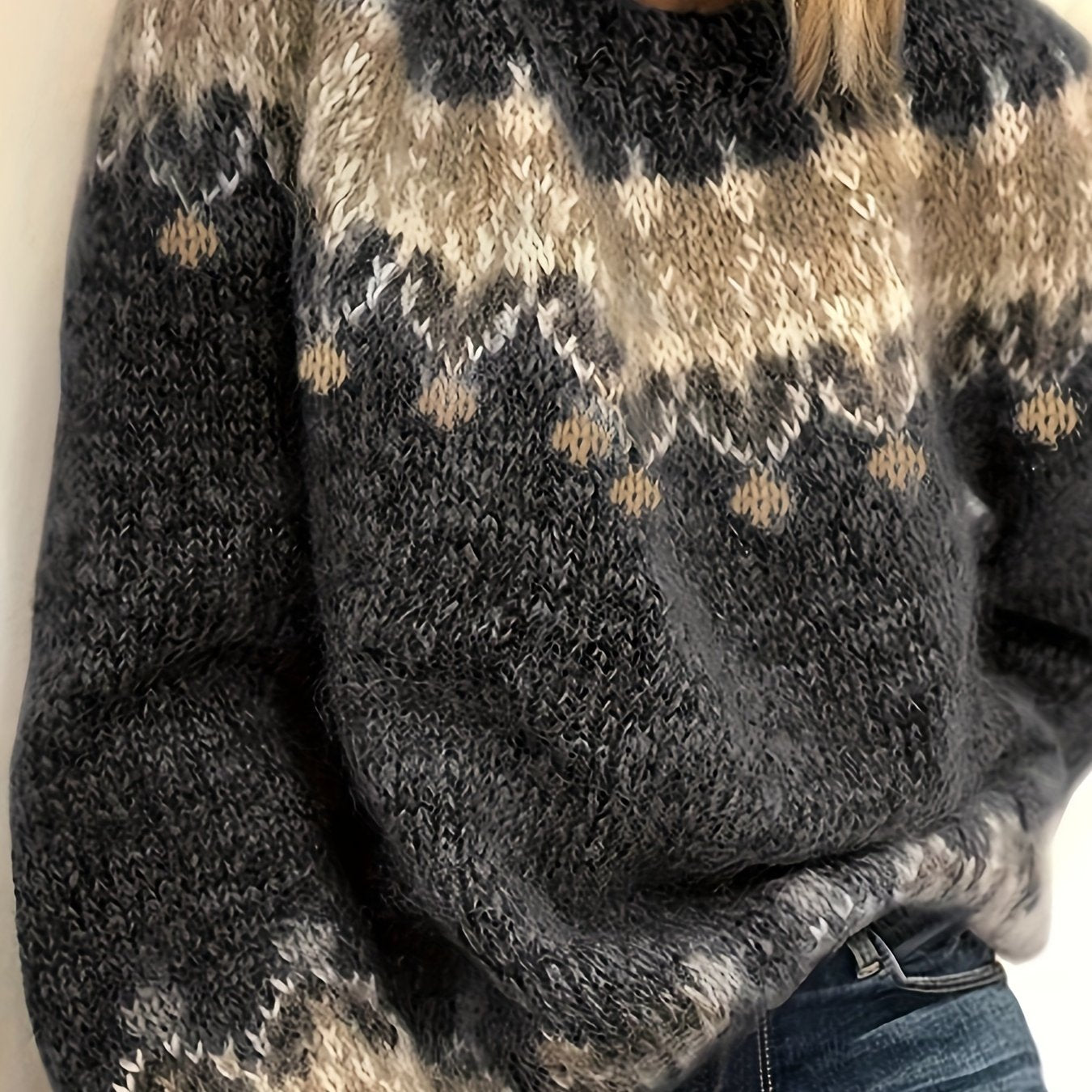 Close-up of a person wearing a patterned sweater with a neutral background