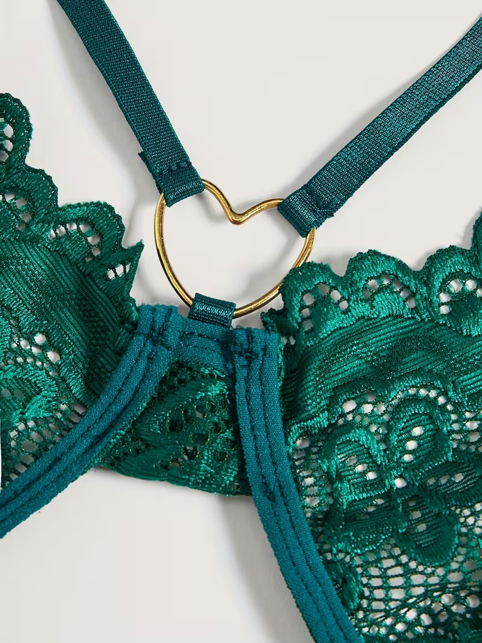 Gold-tone heart ring hardware detail on the emerald lace bodysuit