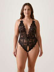 Black crotchless lace bodysuit on model - plus size sheer deep-V lingerie with front bows - Chaotic Fashion